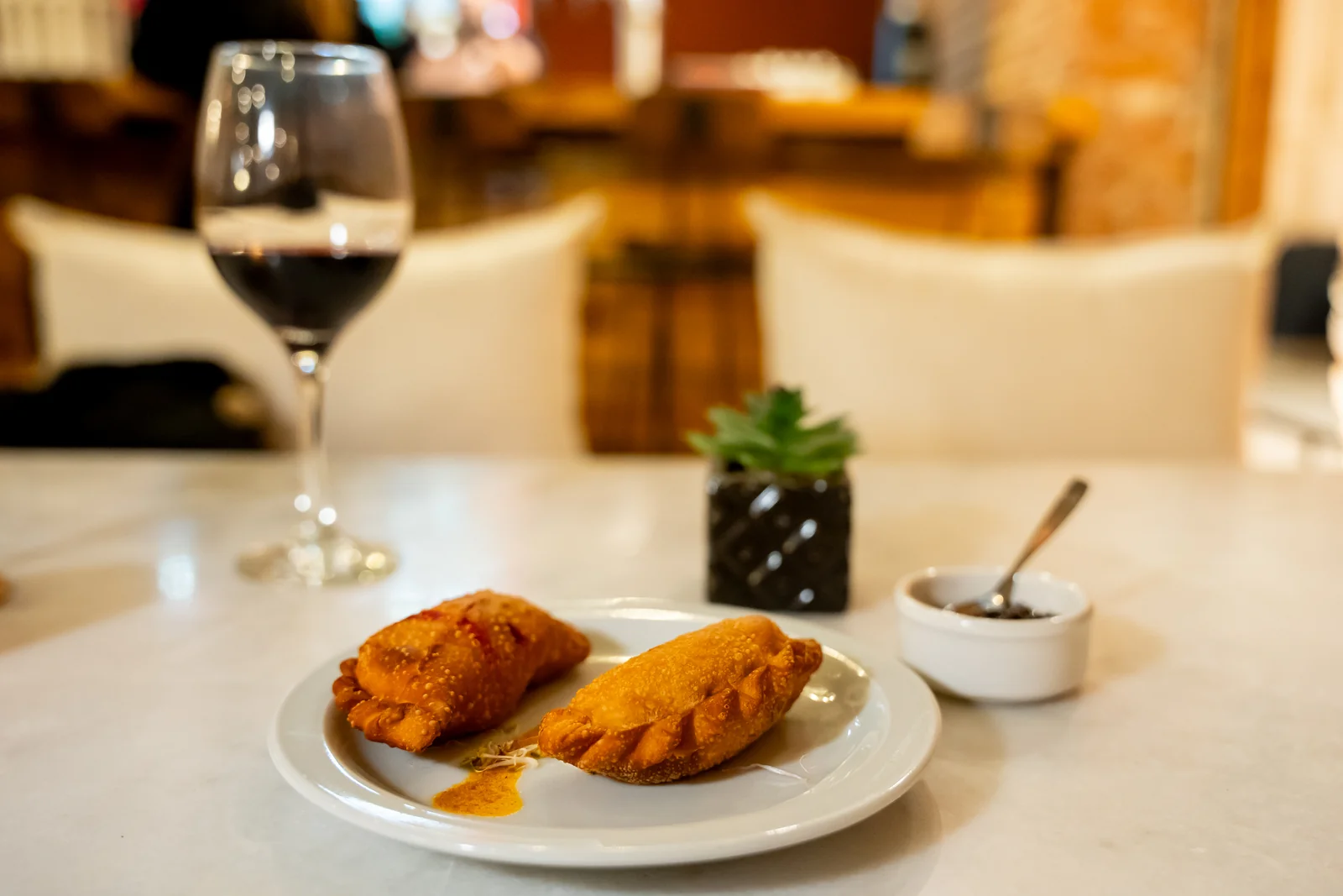 Copa de vino tinto y mesa de mármol a la luz de las velas